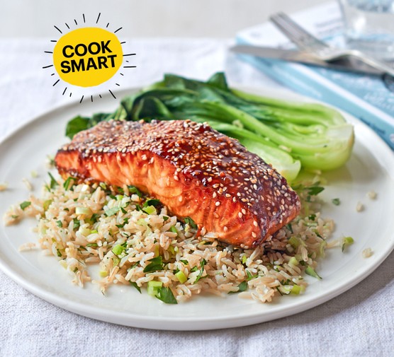 Salmon fillet with rice and pak choi on a white plate