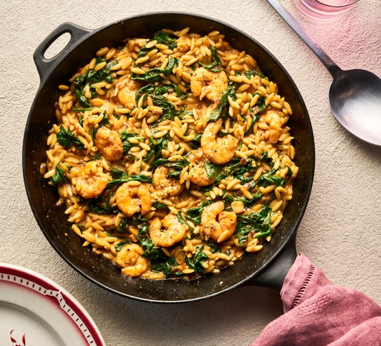 Creamy Cajun prawn orzo sits in a skillet pan