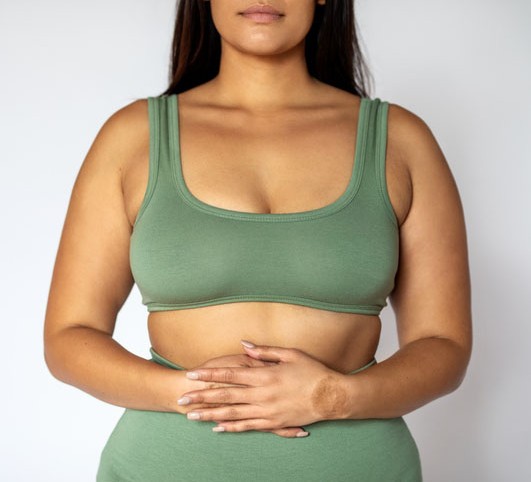 How to lose excess belly fat Midsection shot of a woman in underwear on white background.