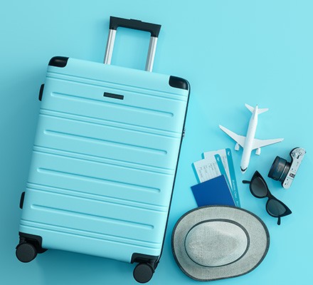 Blue suitcase, hat and sunglasses