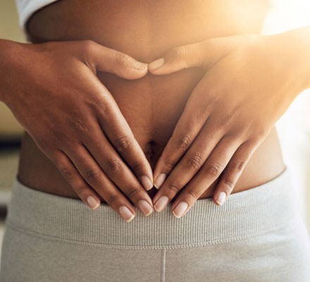 Cropped shot of a sporty young woman making a heart with her hands on her stomach