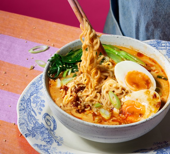 A bowl of creamy tofu & harissa noodles with jammy eggs