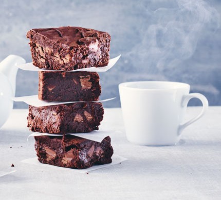 Special diet recipes Stack of gluten-free chocolate brownies next to a mug