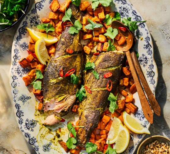 Trout on a bed of sweet potatoes on a platter