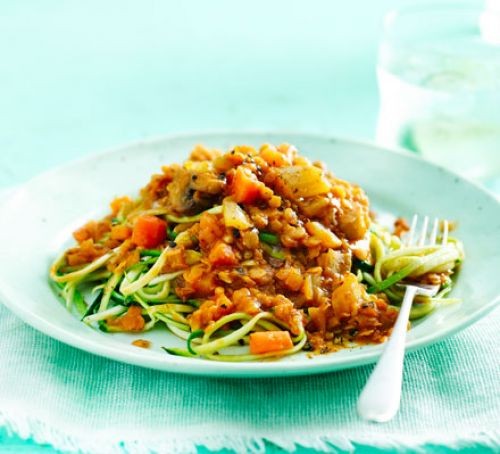 Vegan gluten-free recipes Courgetti topped with lentil ragu, served on a plate with a fork