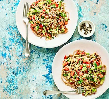 Linguine with chilli, tomato, avocado and lime on two plates