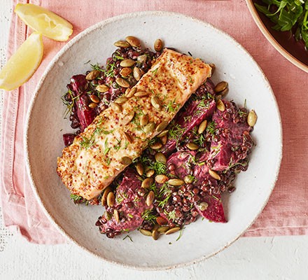 Mustardy salmon with beetroot & lentils served on a plate with lemon wedges
