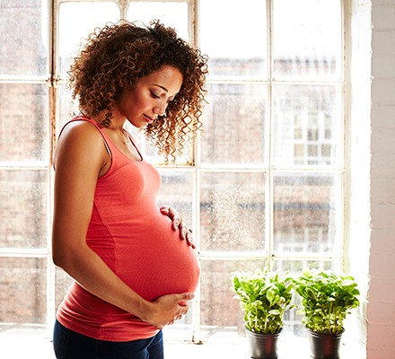 A woman holding her pregnancy bump