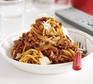 Spaghetti bolognese in a white bowl with parmesan