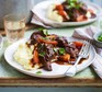 Slow cooker beef stew Beef stew with vegetables on mashed potato on plate with fork
