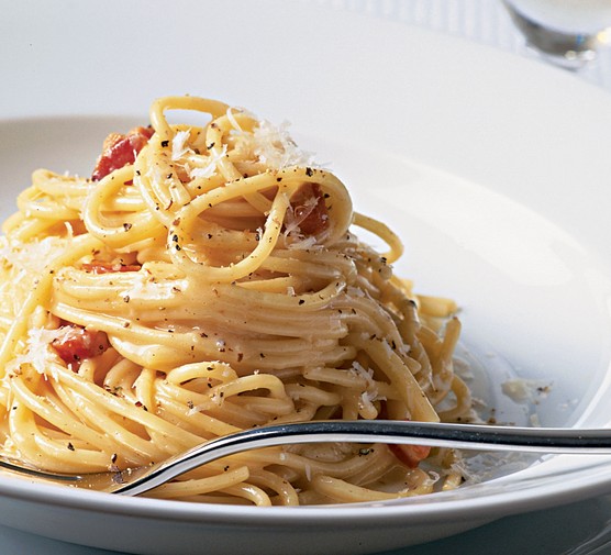 Spaghetti carbonara topped with parmesan and pepper